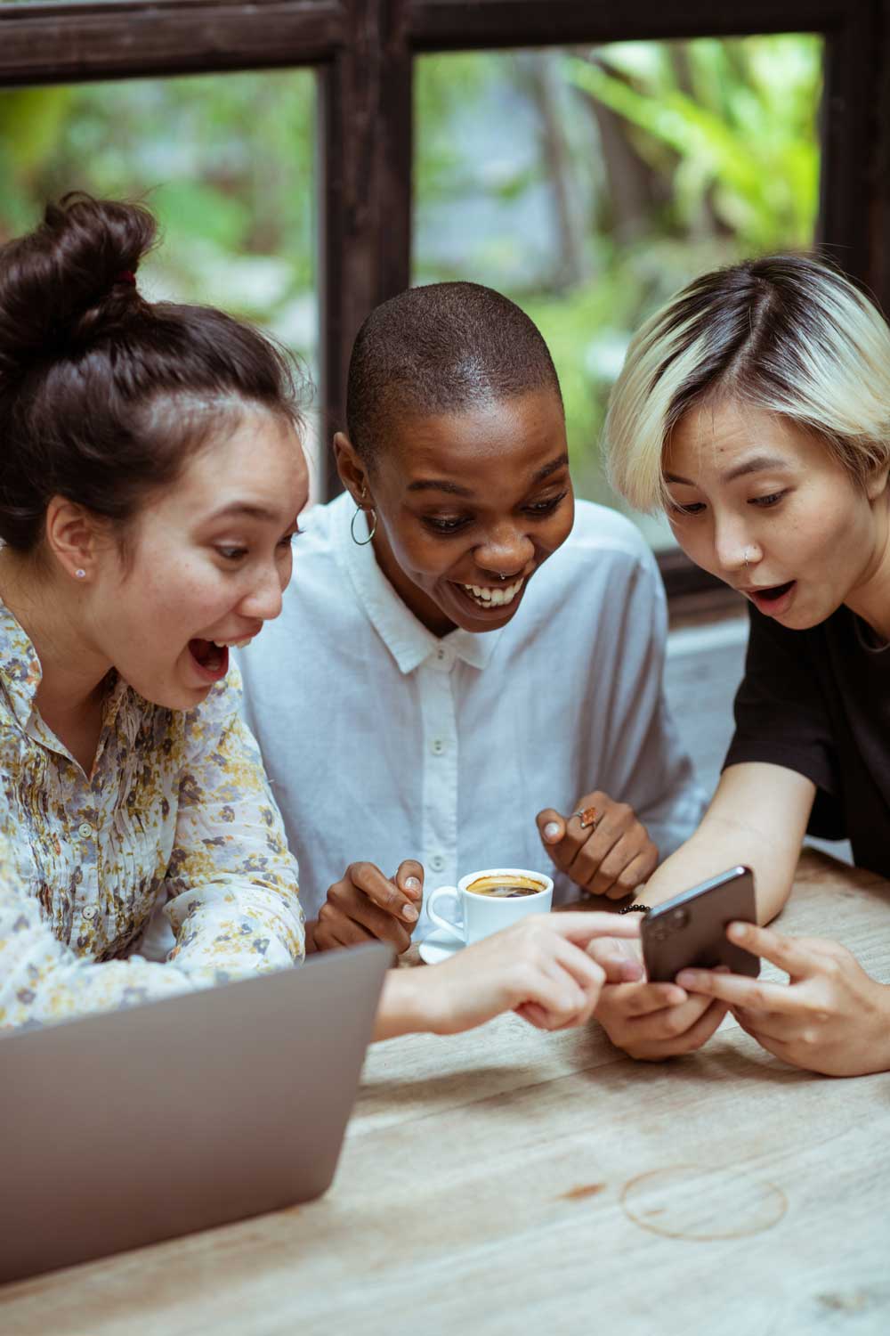 Individuals expressing joy around a phone